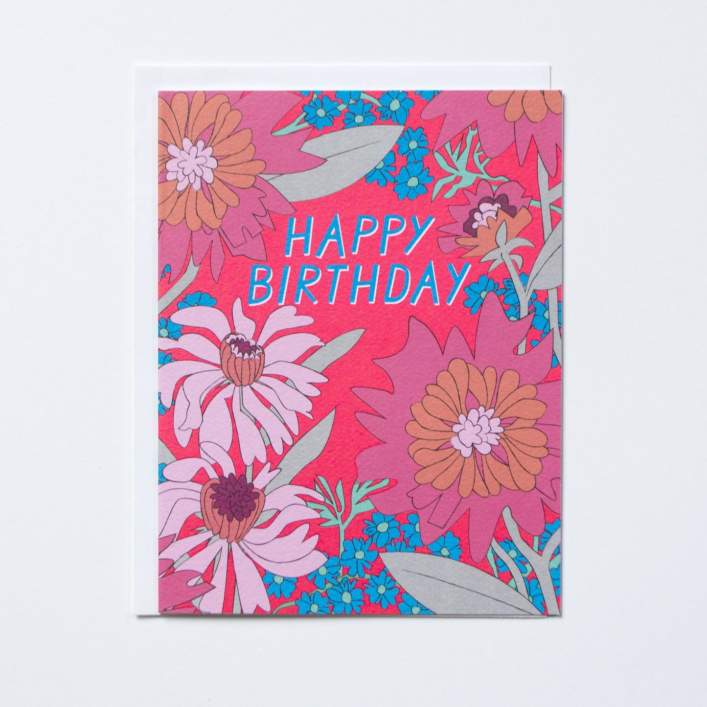 Bright pink card with bright pink, white, blue florals and blue text at middle top that reads 'happy birthday'.